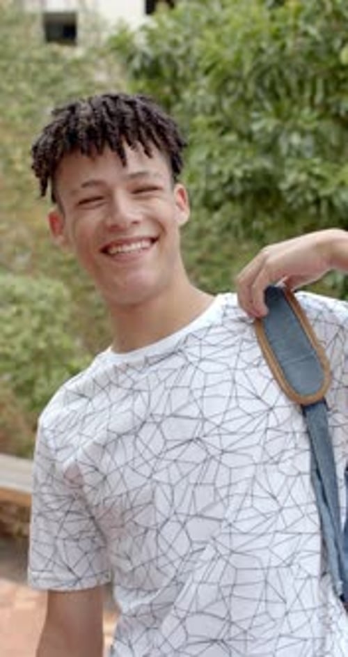 Vidéo verticale : Au lycée, un adolescent biracial sourit vivement
