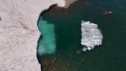 Aerial View of Snow and Emerald Water