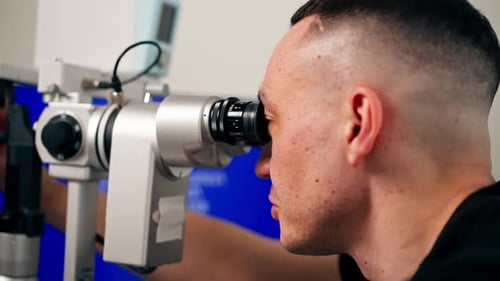 Nahaufnahme in einer Augenklinik diagnostiziert ein junger Arzt die Augen eines jungen Mädchens mit einem