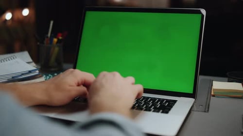 Man Typing on Laptop with Green Screen