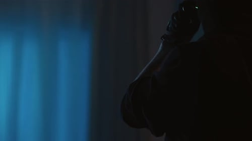 Man in Balaclava Turns on Flashlight Indoors