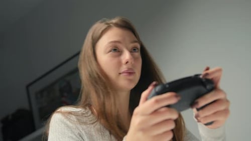 Nahaufnahme: Eine Frau spielt mit einem Joystick oder Gamepad auf einer Konsole. Mädchen spielt Computerspiele