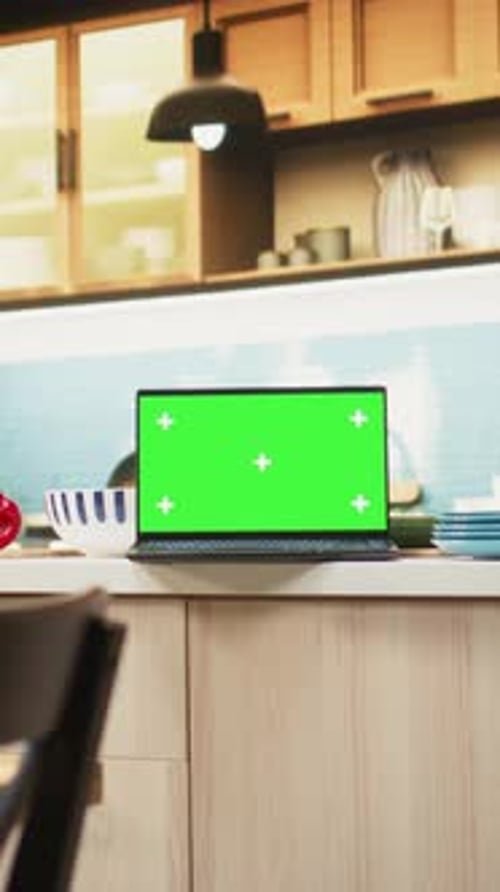 Vertical Video Green Screen on Laptop in Modern Home Kitchen with Cupboards and Cookware