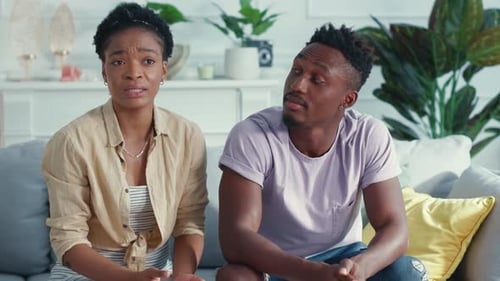 Un couple dans un salon moderne s'engage avec un écran immergé dans leur conversation