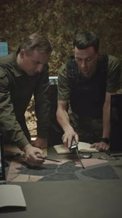 Military Officers Examining Satellite Man in Dark Office