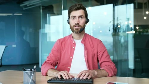 Webcam view of mature business man freelancer with wireless headset looking at the camera and talkin
