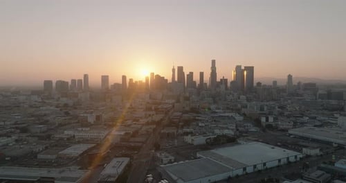a city with a lot of buildings and a sunset