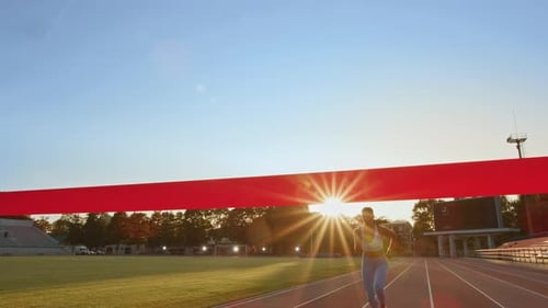 Beautiful Fit Female Runner Crossing the Finish Line on a Professional Sports Arena. Athletic Woman