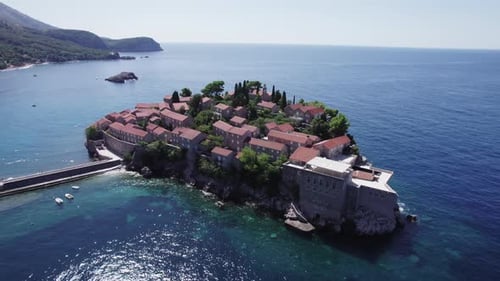 Um drone sobrevoa a ilha de Sveti Stefan em um dia ensolarado em Montenegro