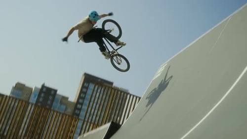 BMX Rider Performing No-Hander Trick in Midair above Ramp at Skate Park
