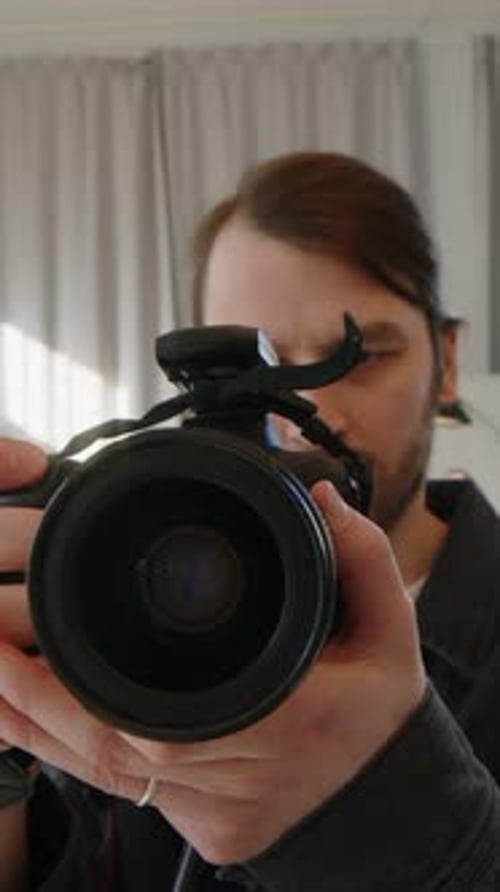 Vertical POV of Male Photographer Taking Pictures in Studio