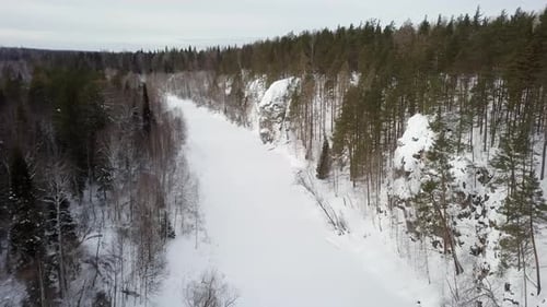 A Serene Winter Landscape Featuring a Frozen River Alongside SnowCovered Trees and Natures Beauty