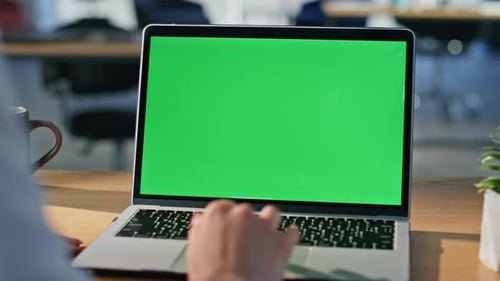 Student Watching Green Screen Laptop at Modern Apartment Workplace Closeup