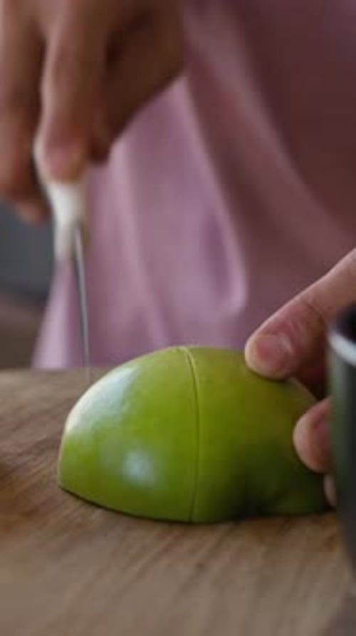 Hands of Man schneidet grünen Apfel zum Frühstück in der Küche zu Hause