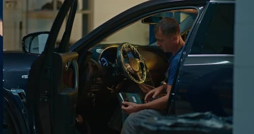 Mechanic Using Tablet Pc at the Repair Garage Service