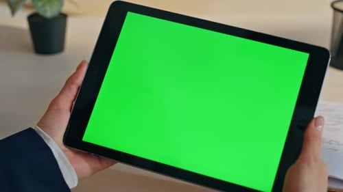 Woman Holding Tablet With Green Screen In Office