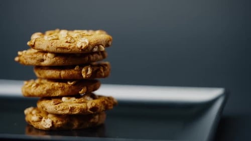 Close Up on Black and Blue Background Flat Plate with Cookie Cookies Built in a Pyramid Sweet