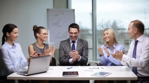 Business team applauding success after a productive meeting in the office