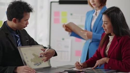 Business Team Discusses Charts and Graphs in Office