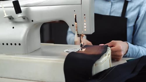 Person Sewing Fabric on a Sewing Machine