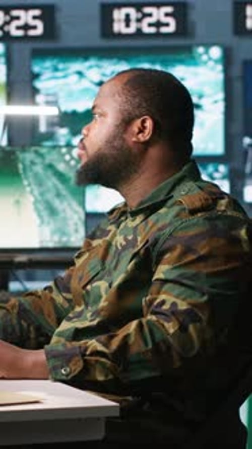 Man in Camouflage Uniform Working at Computer