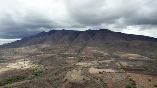 The dramatic journey towards towering mountains shrouded in tempestuous clouds, offering a potent di