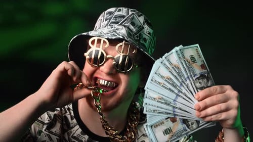 Young Man Smiles with Money and Gold Jewelry