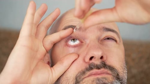 Adult Man Applying Eye Drops, Close Up