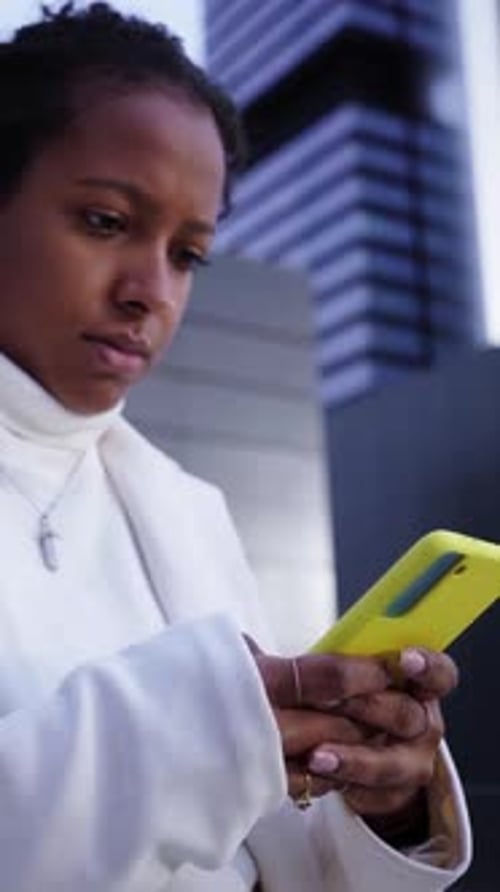 Serious Black Businesswoman Outside Financial District Working Using Phone to Send Online Messages