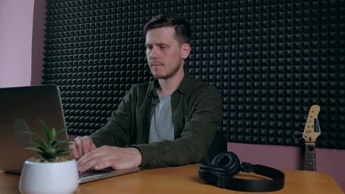 Sound Designer Working on Notebook in Music Studio