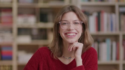 Smiling Woman with Glasses in Front of Bookshelf