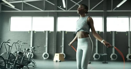 Jump, skipping rope or black woman in gym with fitness for body health, training