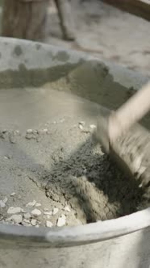 Unrecognizable Man Mixing Concrete with Rocks in a Building Site FHD Vertical Video