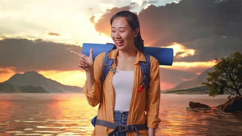 Asian Female Hiker Smiling And Pointing To Side At A Lake