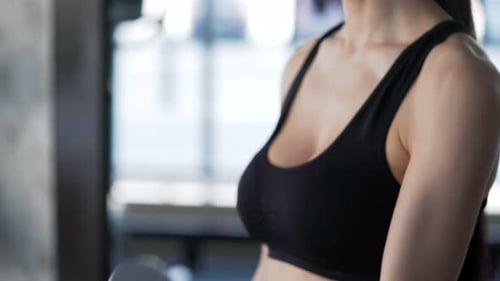 Brunette with Slender Physique Doing Exercises Using Dumbbells. One Real Person 20s