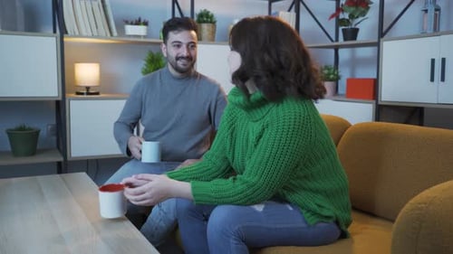 Couple Chatting, Drinking Coffee in Living Room