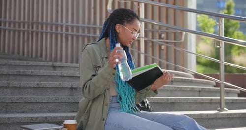 Woman Reads Book on Urban Steps