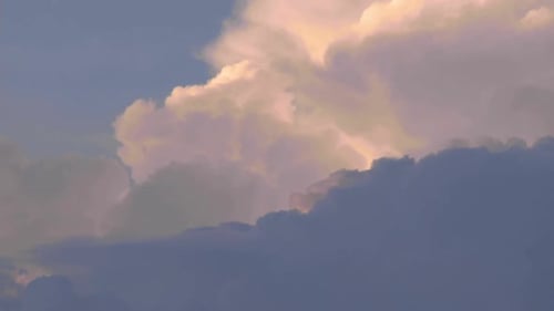 Billowing clouds, cumulonembus growing a storm at the sunset. Atmosphere