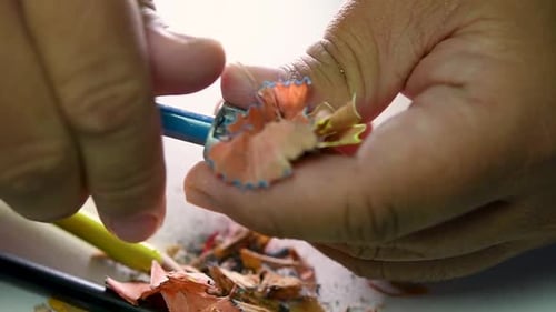 Footage of hands slowly sharpening a pencil and some coloured pencils with a Wedge Pencil Sharpener.