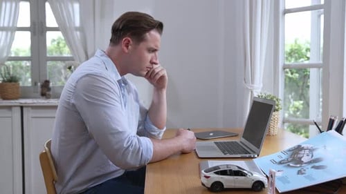 Un
designer automobile analyse soigneusement un prototype de voiture. Fastidieux