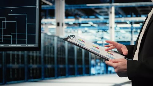 Close Up of Data Center Engineer Reading Clipboard Files Charts