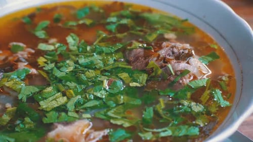 Plate of Georgian Traditional Khashlama Soup on a Wooden Table in a Restaurant