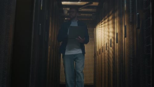 Young Skilled Male Data Center Administrator Servicing Rack Server Cabinets