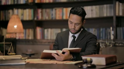 Lawyer Reading Law Book at His Desk