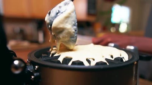 Adding more batter to the waffle iron for a delicious breakfast - slow motion isolated