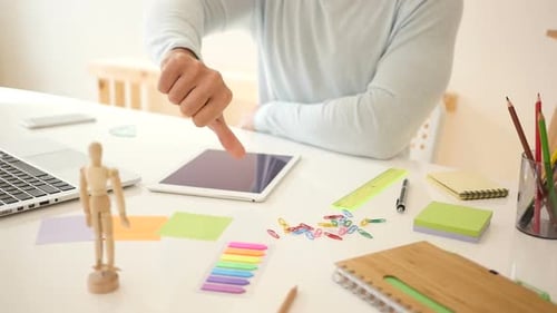 Thumb Down on Tablet at Workplace