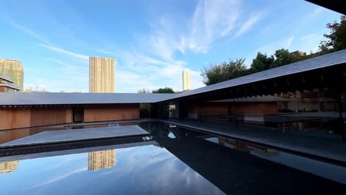 A serene modern courtyard with a reflective water pool surrounded by minimalist architecture