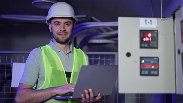 Electrical Engineer Monitors Switchboard with Laptop in Server Room ...