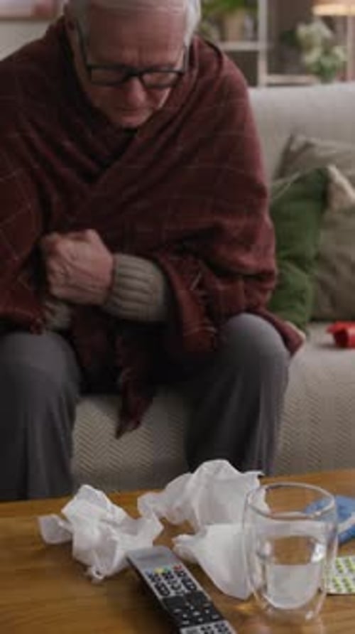 Man Feeling Ill Sitting on Couch at Home