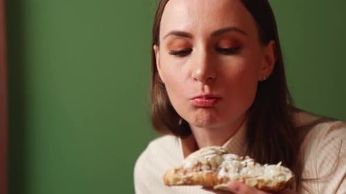 Woman Eats a Croissant and Drinks Tea